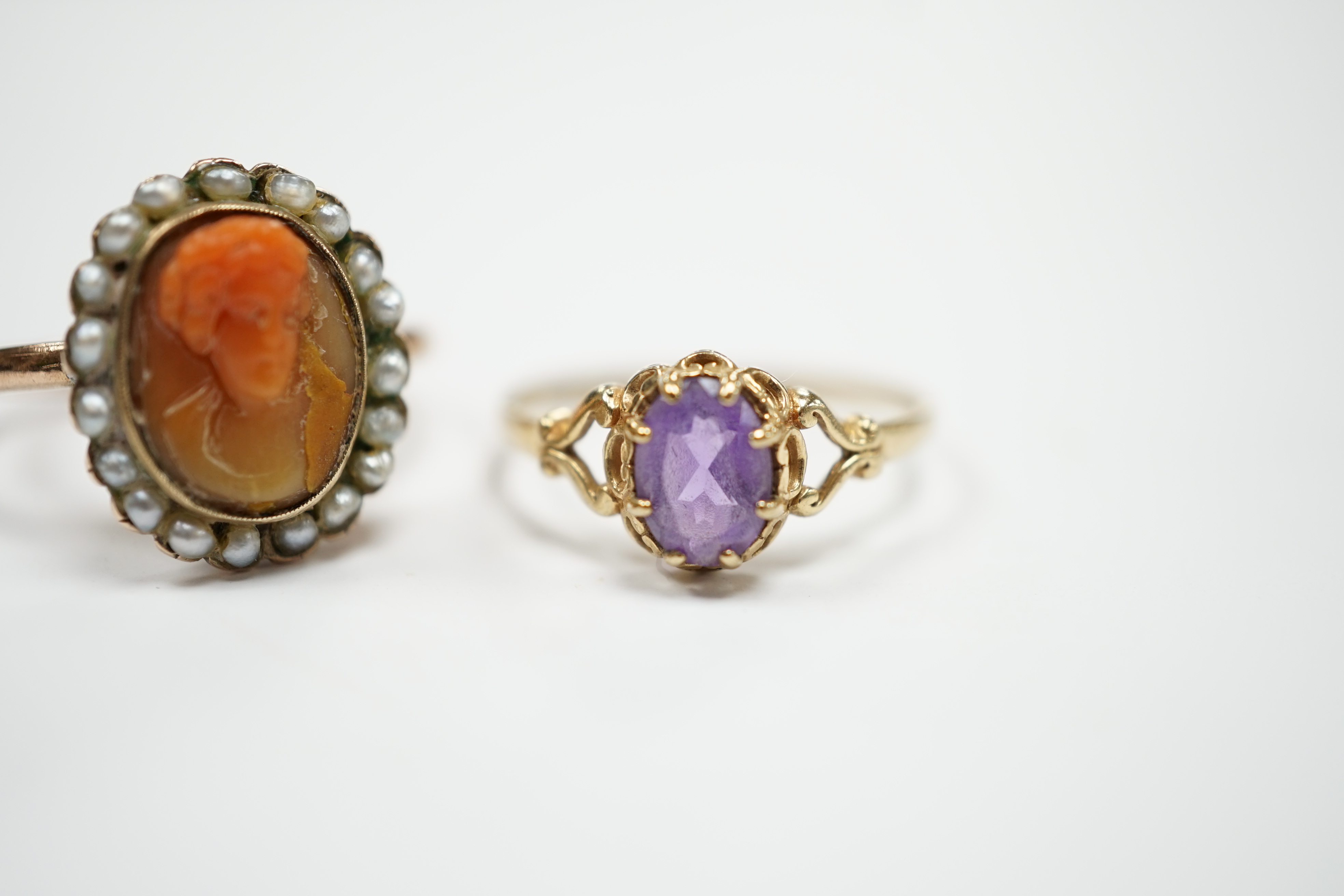 A modern 9ct gold and single stone amethyst set ring and a yellow metal, carved coral and split pearl set ring.